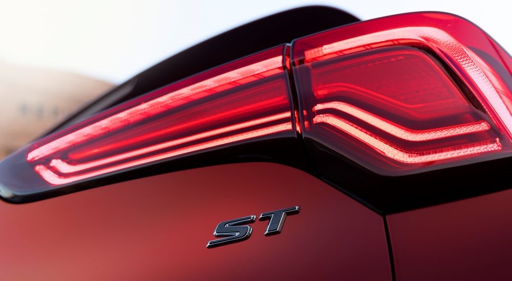 A close-up on the taillight of a red 2024 Buick Encore GX ST is shown.