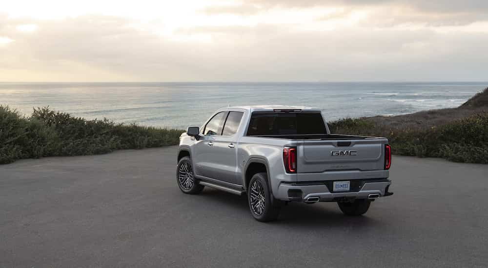 A silver 2025 GMC Sierra 1500 Denali Ultimate is shown from the rear at an angle.