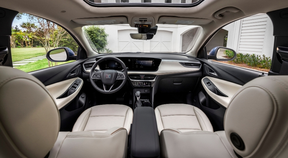 The white interior of a 2025 Buick Encore GX Avenir is shown from the rear seats.