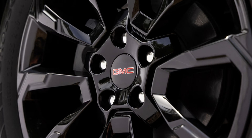 A close-up shows a black wheel on a 2025 GMC Terrain Elevation.