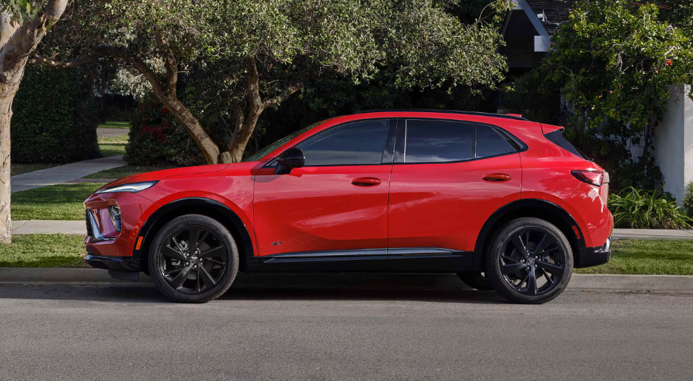 Red 2026 Buick Envision parallel parked outside of a Buick dealer near Owosso