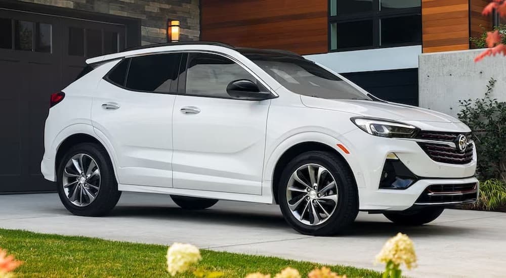 A white 2023 Buick Encore GX parked near a house.