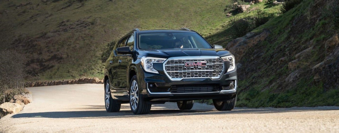 Black 2022 GMC Terrain Denali driving up an open road