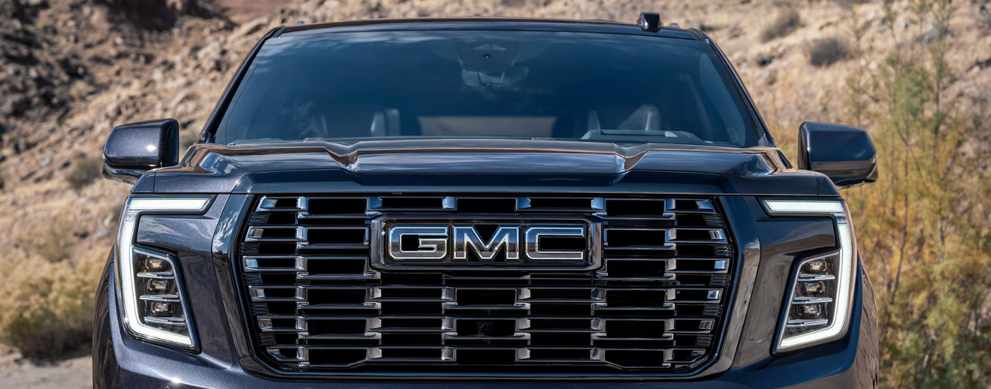 Close-up of the grille of a black 2026 GMC Yukon