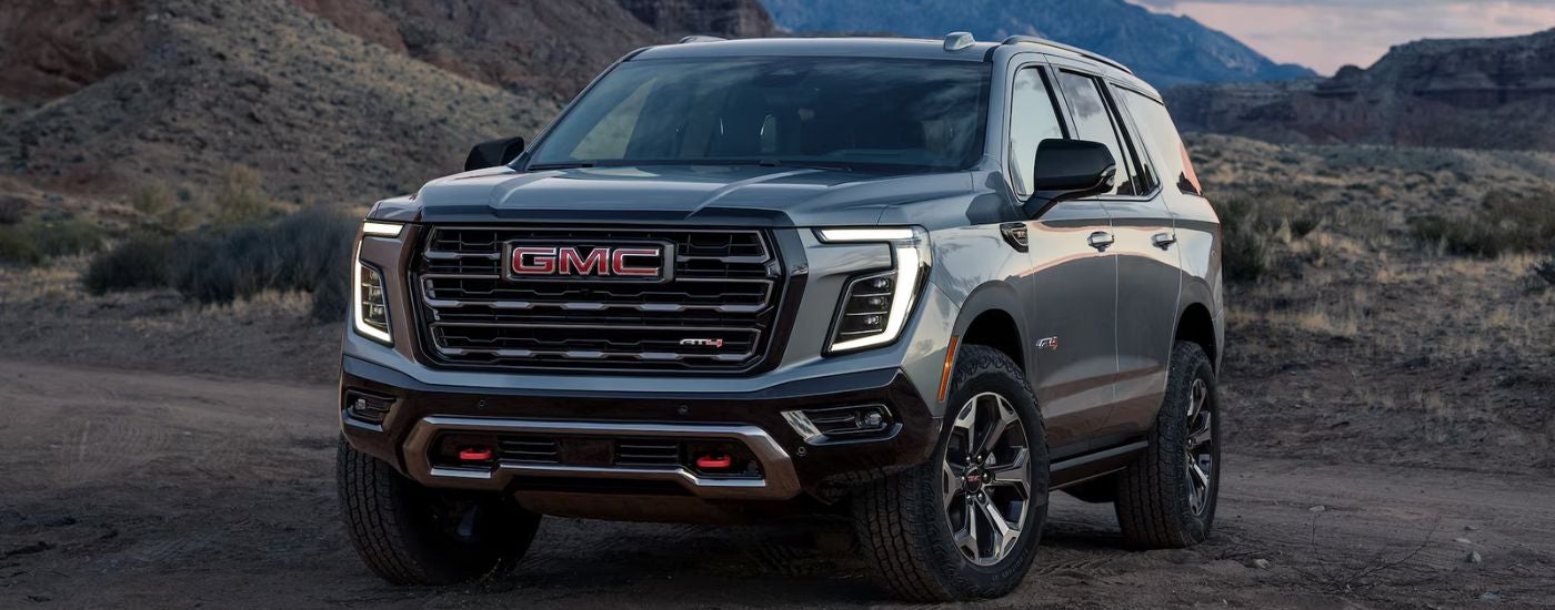 Grey 2026 GMC Yukon AT4 parked off-road in the desert.