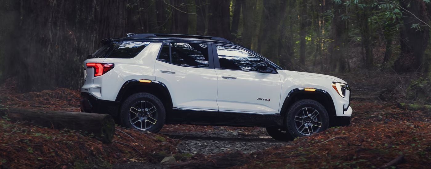 White 2026 GMC Terrain AT4 side view in the woods.
