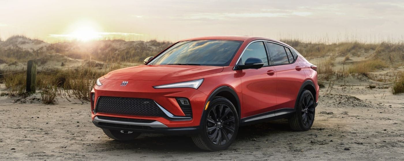 A red 2024 Buick Envista ST is shown angled left and parked off-road in a desert.