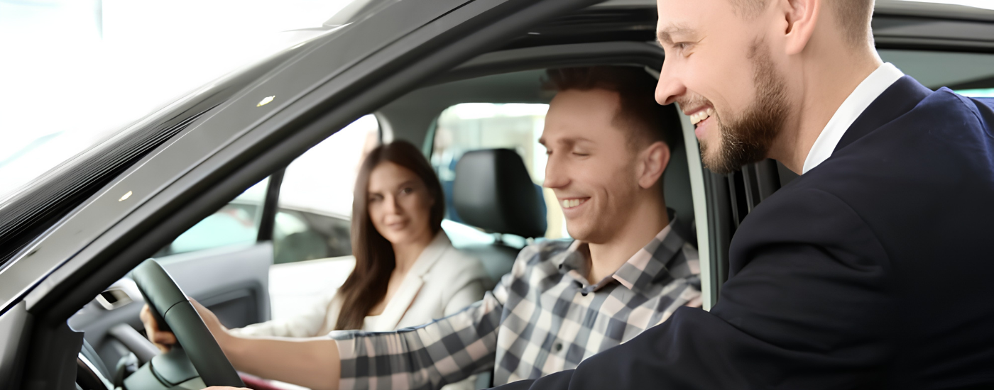 A couple inside a car talking to a salesman