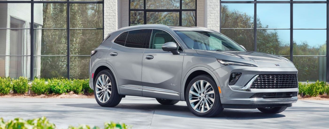 Silver 2024 Buick Envision Avenir parked in a showroom. 