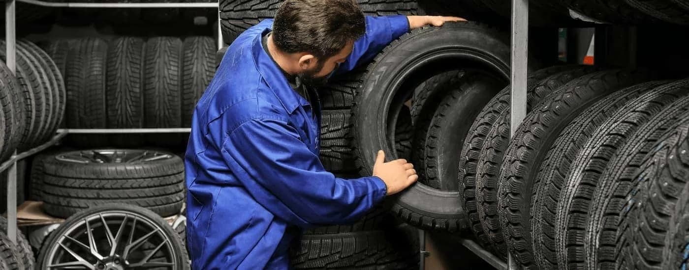 Mechanic loading a tire onto a rack.